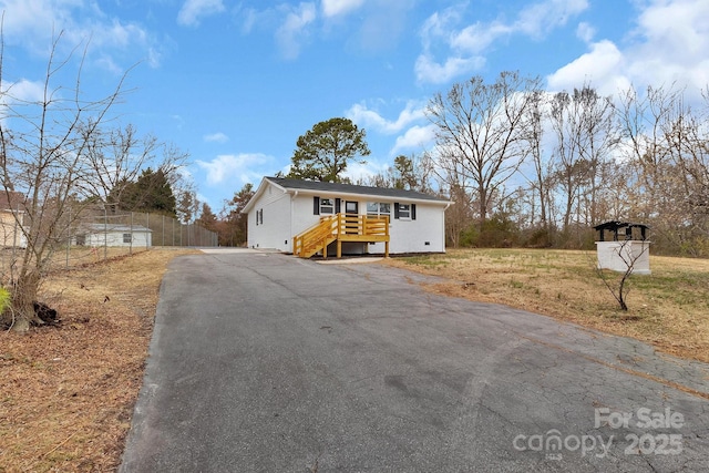 view of front of house featuring fence and aphalt driveway