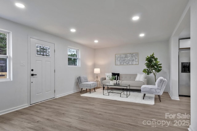 living room featuring baseboards, wood finished floors, and recessed lighting