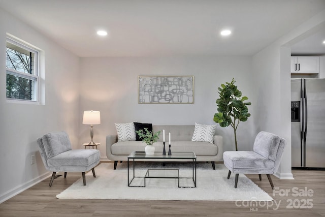 living room featuring recessed lighting, light wood-style flooring, and baseboards