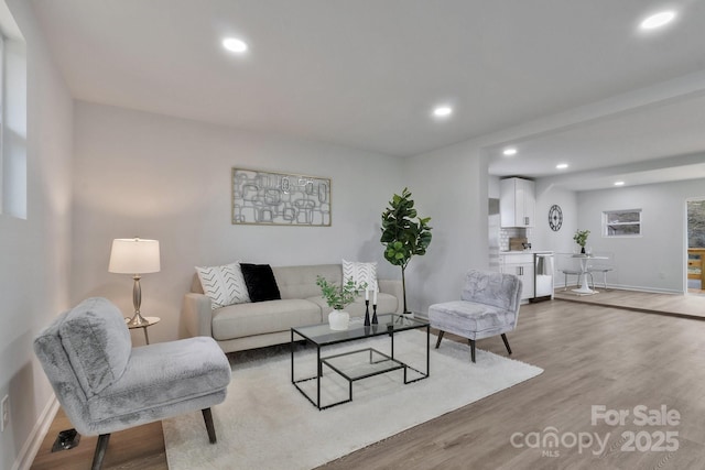 living room with recessed lighting, baseboards, and wood finished floors