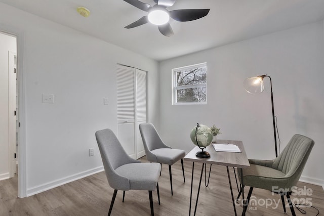 interior space featuring wood finished floors, a ceiling fan, and baseboards