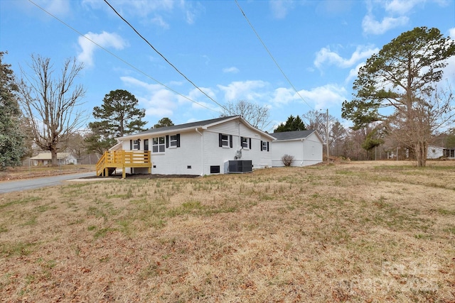 rear view of property featuring a yard, brick siding, and central air condition unit