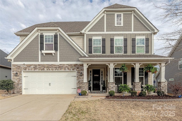 craftsman house featuring stone siding, board and batten siding, a porch, and concrete driveway