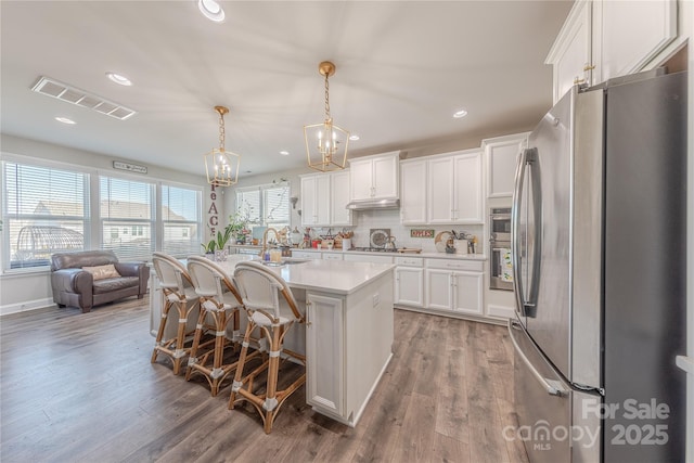 kitchen featuring visible vents, white cabinetry, light wood-style floors, appliances with stainless steel finishes, and light countertops