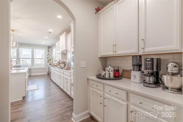 kitchen featuring a sink, tasteful backsplash, and white cabinetry