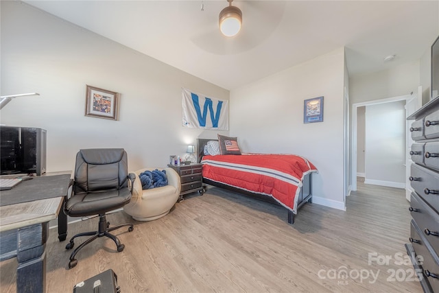 bedroom featuring baseboards, wood finished floors, and a ceiling fan