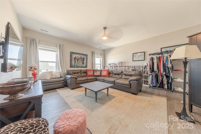 living area with visible vents, light wood-style floors, and ceiling fan