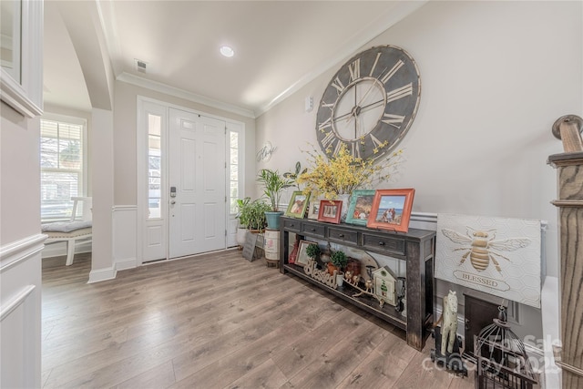 entrance foyer featuring wood finished floors, visible vents, and ornamental molding