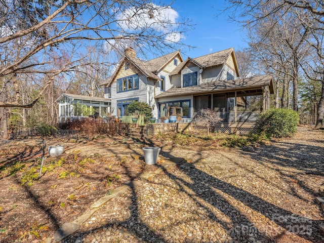 view of front of property with a chimney and a sunroom