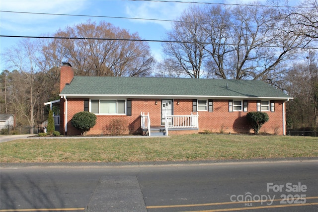 single story home with brick siding, a chimney, a front lawn, and roof with shingles