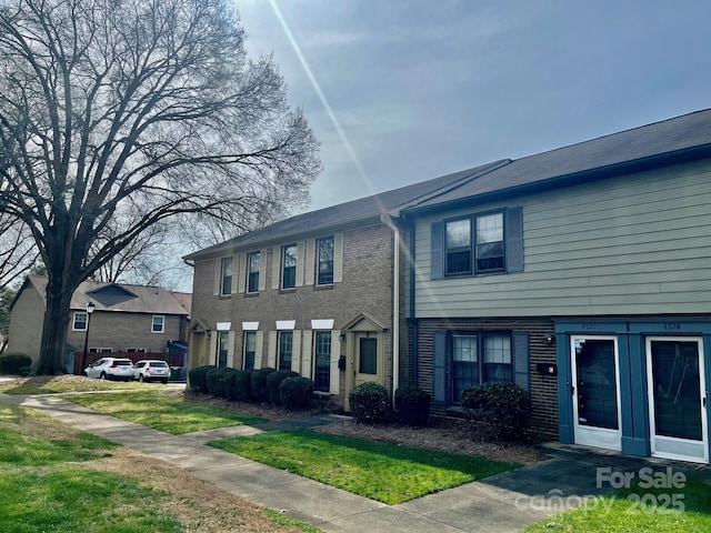 view of front of property featuring a front lawn and brick siding