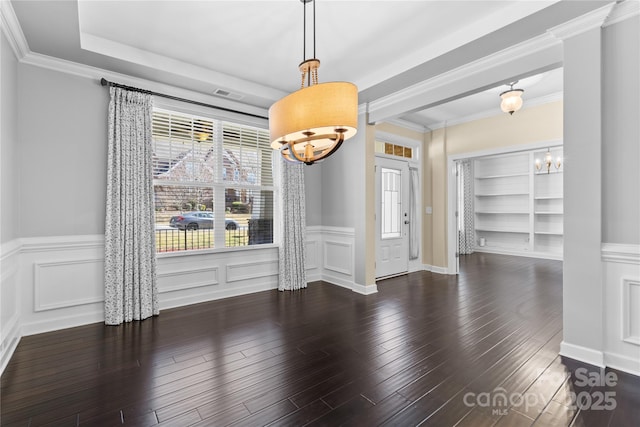 unfurnished dining area with a decorative wall, visible vents, an inviting chandelier, and wood finished floors