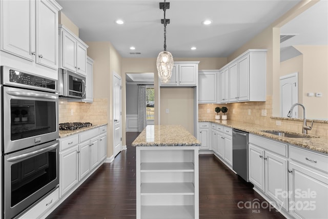 kitchen with a sink, stainless steel appliances, open shelves, and white cabinets