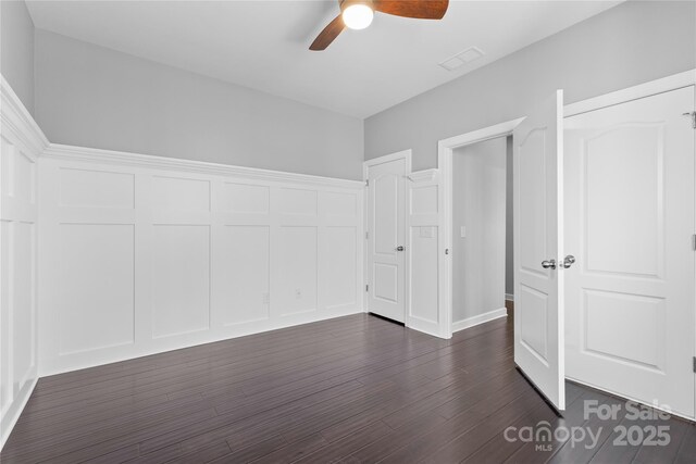 unfurnished bedroom featuring visible vents, dark wood-style floors, and a ceiling fan