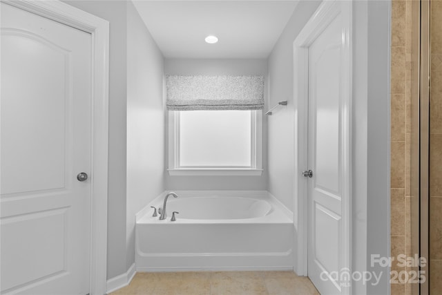 bathroom featuring tile patterned flooring and a bath
