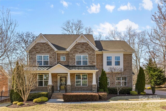 craftsman-style house featuring brick siding, a porch, and a shingled roof
