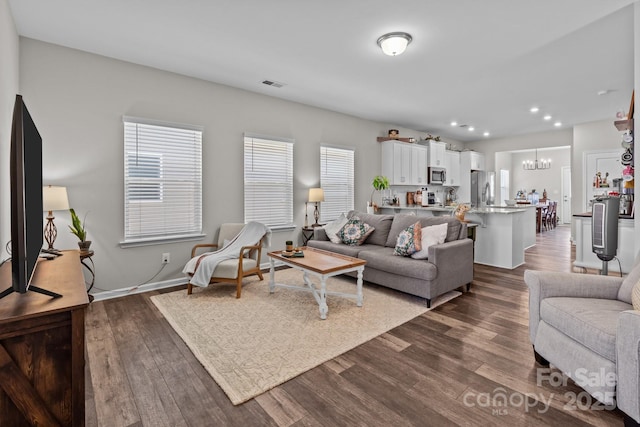 living room with visible vents, baseboards, dark wood finished floors, recessed lighting, and a notable chandelier