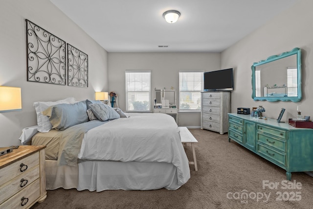 bedroom with visible vents and dark carpet