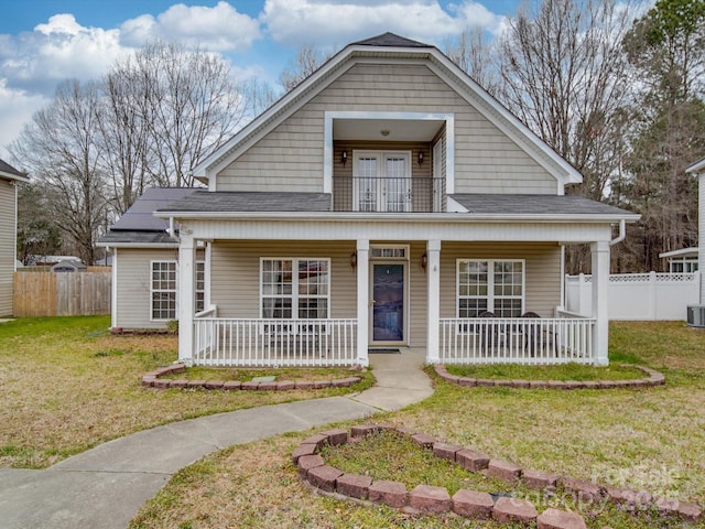 bungalow-style house featuring a porch, a front yard, fence, and a shingled roof