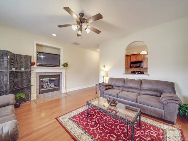 living area with baseboards, visible vents, wood finished floors, a fireplace, and recessed lighting