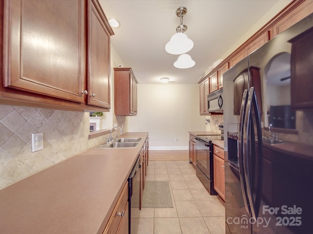 kitchen with brown cabinets, black electric range oven, backsplash, a sink, and dishwashing machine