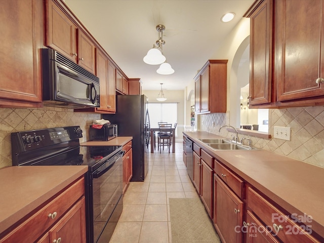 kitchen featuring light tile patterned floors, black appliances, a sink, and decorative backsplash