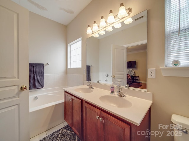 bathroom with tile patterned floors, a sink, toilet, and a bath