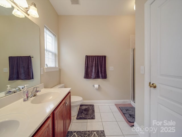 bathroom with double vanity, baseboards, tile patterned flooring, an enclosed shower, and a sink