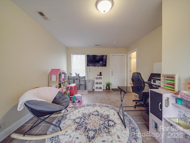 tiled office space with baseboards and visible vents