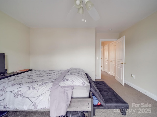 carpeted bedroom with ceiling fan and baseboards