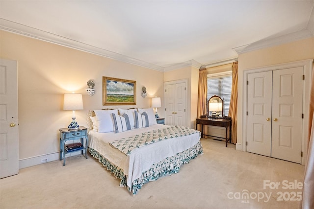 bedroom with light colored carpet, two closets, crown molding, and baseboards