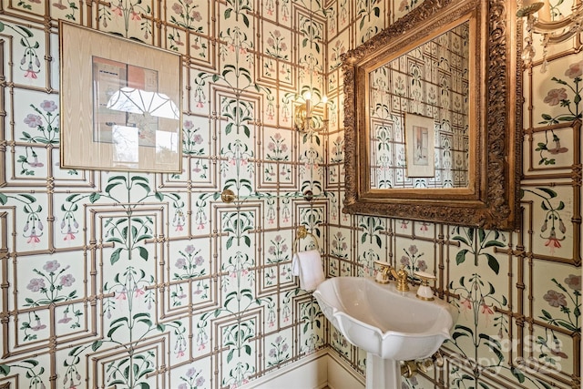 bathroom featuring wallpapered walls and a sink