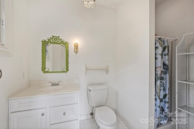 bathroom with baseboards, toilet, vanity, and tile patterned flooring