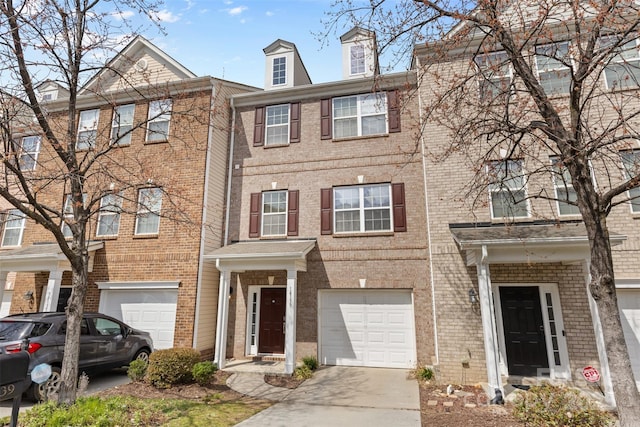 townhome / multi-family property with brick siding, concrete driveway, and an attached garage