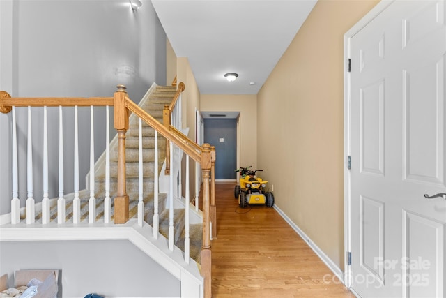 staircase with baseboards and wood finished floors