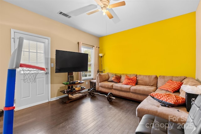 living area with baseboards, visible vents, wood-type flooring, and ceiling fan