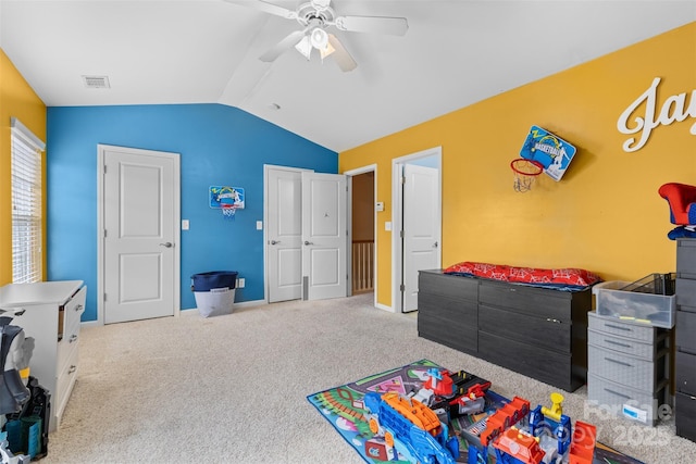 recreation room featuring carpet, a ceiling fan, visible vents, baseboards, and vaulted ceiling