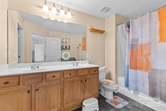 bathroom featuring double vanity, visible vents, toilet, and a sink