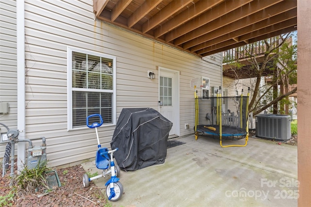 view of patio / terrace with central AC unit, a grill, and a trampoline