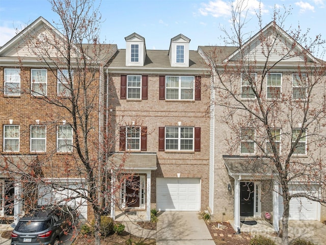 multi unit property with a garage, brick siding, and concrete driveway