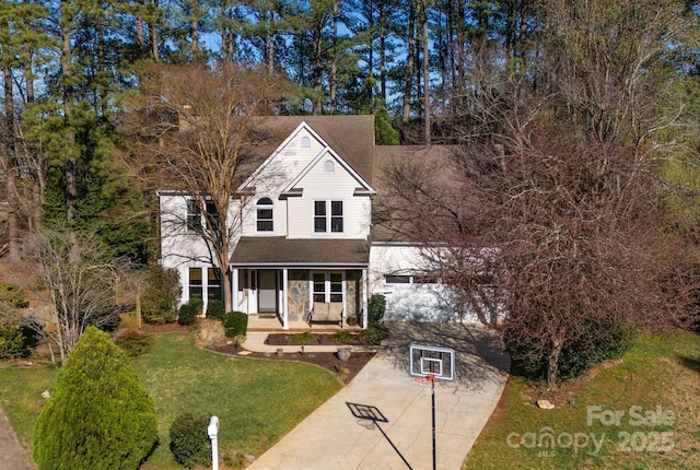 traditional-style home with a front lawn, stone siding, covered porch, concrete driveway, and a shingled roof