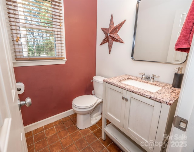 bathroom featuring tile patterned floors, baseboards, toilet, and vanity