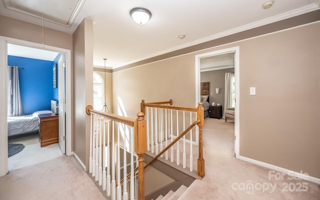 corridor with attic access, an upstairs landing, baseboards, and carpet floors