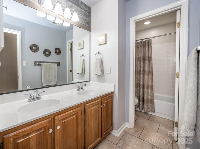 full bath featuring double vanity, tile patterned flooring, toilet, and a sink