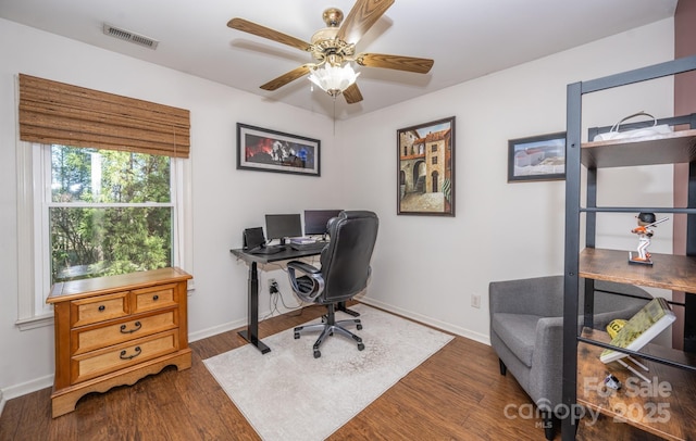 home office featuring visible vents, baseboards, wood finished floors, and a ceiling fan