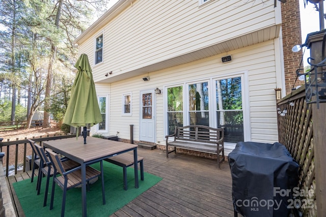 deck with grilling area and outdoor dining space