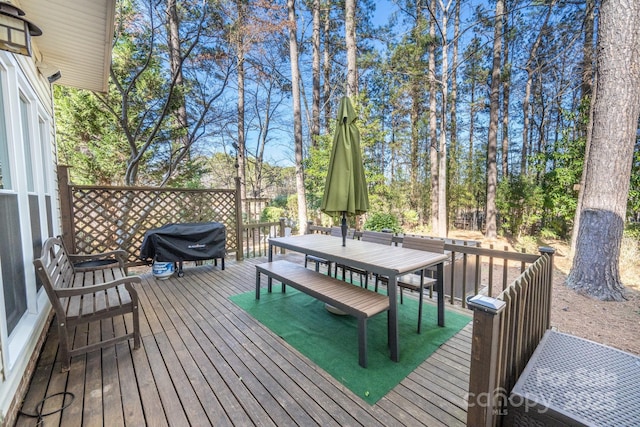 wooden terrace featuring grilling area and outdoor dining area