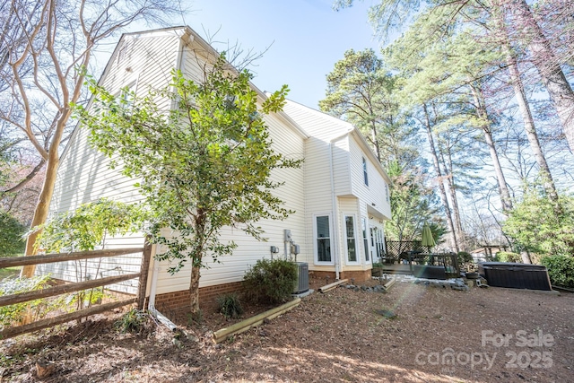 view of home's exterior featuring central AC and a hot tub