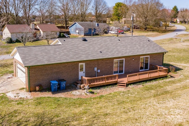 back of house featuring a yard, brick siding, a residential view, and a wooden deck