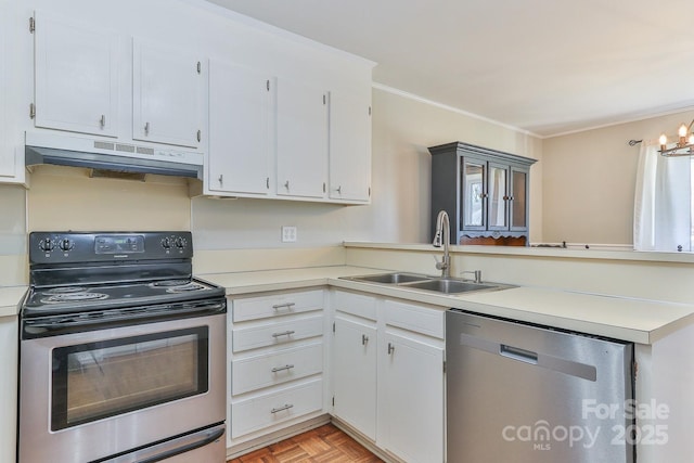 kitchen with under cabinet range hood, a sink, appliances with stainless steel finishes, a peninsula, and light countertops